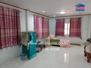 Living room with patterned curtains, seating area, and freezer