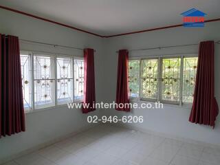 Living room with large windows and red curtains