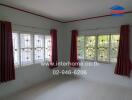 Living room with large windows and red curtains