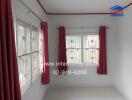 Living room with large windows and red curtains