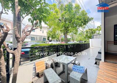 Outdoor seating area with trees and neighboring houses