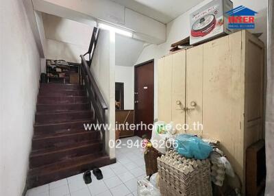 Entrance area with staircase, storage cabinets, and various items