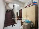 Entrance area with staircase, storage cabinets, and various items