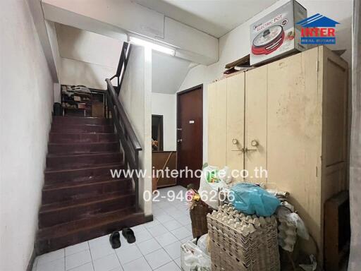 Entrance area with staircase, storage cabinets, and various items