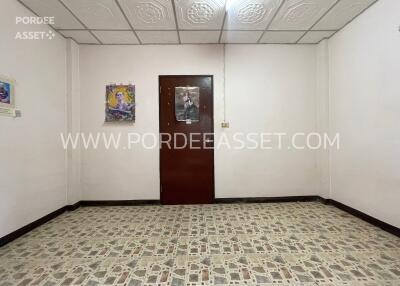 Empty bedroom with a wooden door and tiled floor