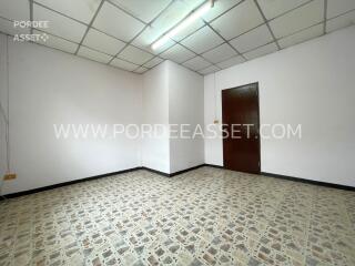 Empty room with tiled floor and wooden door