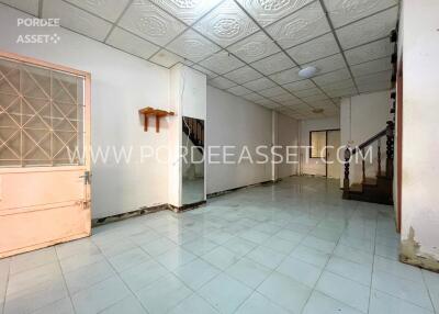 Empty living space with staircase and door