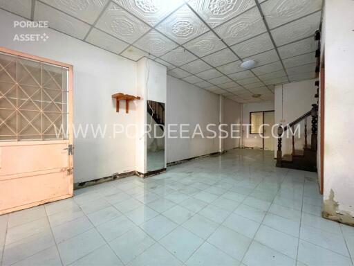 Empty living space with staircase and door