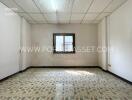 Unfurnished room with window and patterned floor tiles