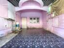 Spacious covered area with pink walls and patterned floor tiles