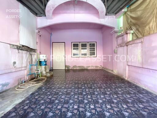 Spacious covered area with pink walls and patterned floor tiles