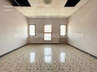 Spacious empty bedroom with tiled floor and windows