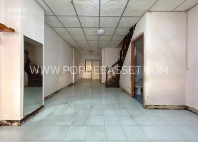 Spacious unfurnished interior space with white tile flooring and ceiling panels