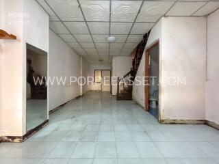 Spacious unfurnished interior space with white tile flooring and ceiling panels