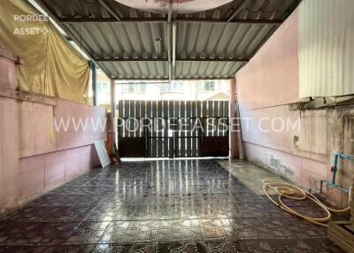 Covered garage with tiled floor and hose