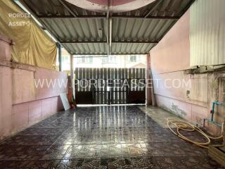 Covered garage with tiled floor and hose