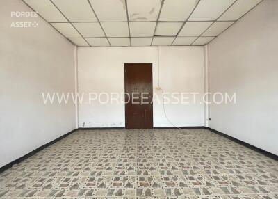 Spacious empty room with tiled floor and wooden door