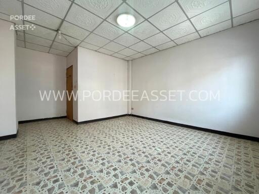 Empty room with patterned floor tiles and a ceiling light