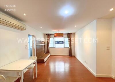 Spacious living room with wooden flooring and natural light