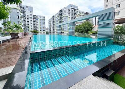 Modern apartment complex with clear blue swimming pool and surrounding greenery