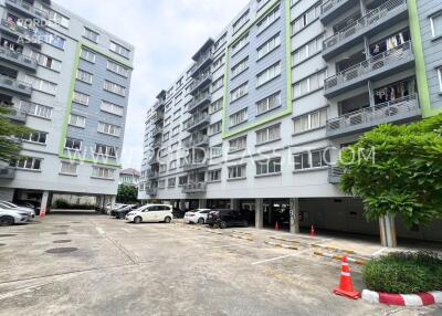 Outdoor view of a residential building with multiple floors and parked cars