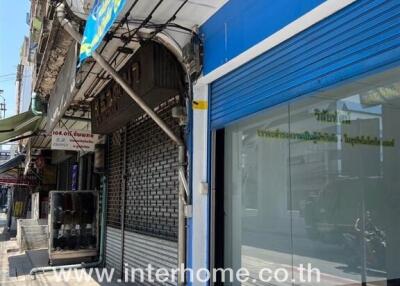 Facade of a commercial building with signage and closed roller shutters