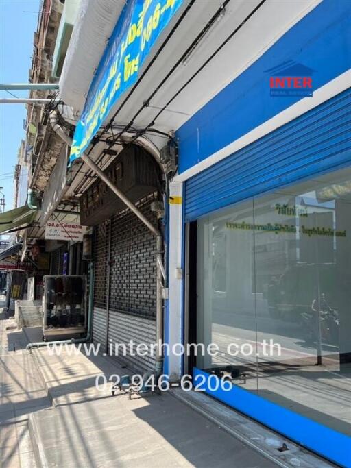 Facade of a commercial building with signage and closed roller shutters