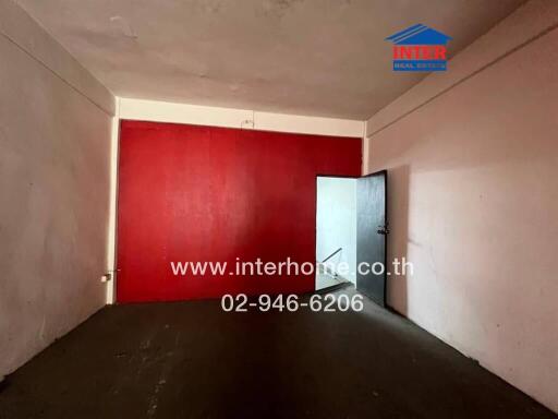 Empty room with red accent wall and open door