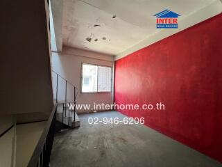 Room with red accent wall and staircase