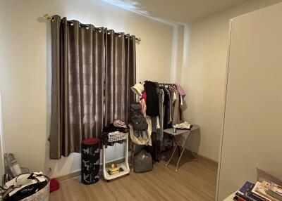 Bedroom with clothes rack and books