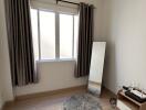 Cozy bedroom with a large window, mirror, and a small rug