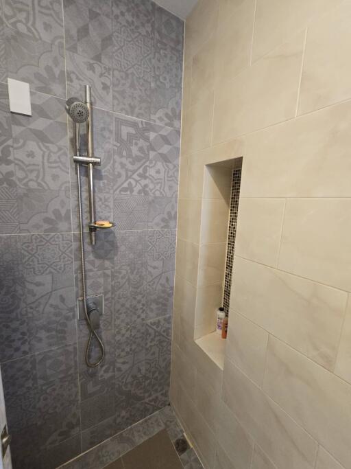 Modern bathroom shower area with patterned and plain tiles