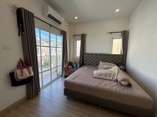 Modern bedroom with large window and balcony access