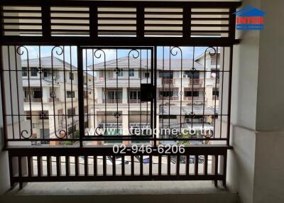 View from the balcony featuring a metal railing and nearby residential buildings