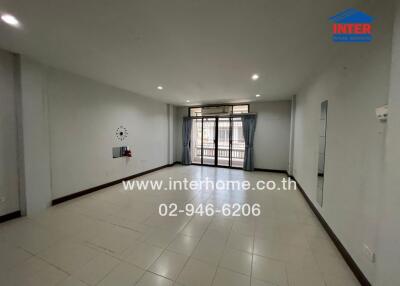 Spacious living room with large windows and tiled floor