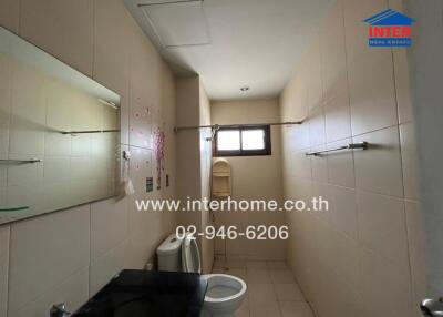 bathroom with sink, toilet, and tiled walls