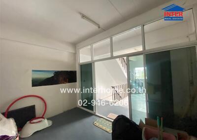 Living area with large sliding glass door and stairway view