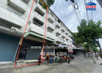 Exterior view of a commercial building with balconies and street