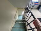 Stairway inside a building with tiled steps and metal railings