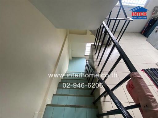 Stairway inside a building with tiled steps and metal railings