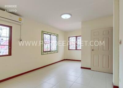 Bright bedroom with windows, air conditioner, and tiled flooring