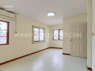 Bright bedroom with windows, air conditioner, and tiled flooring