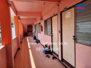 A corridor of an apartment building with doors and windows of individual units.