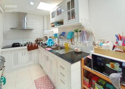 Compact and modern kitchen with white cabinetry and black countertop