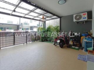 Covered garage area with motorbike and storage shelves