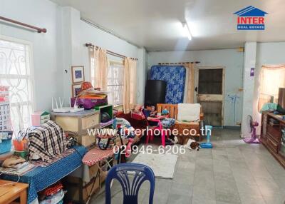 Interior view of a cluttered living area with furniture and household items