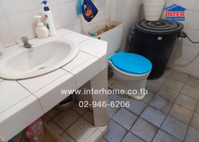 Bathroom with sink, toilet, and storage shelf