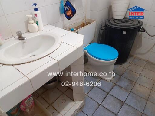 Bathroom with sink, toilet, and storage shelf