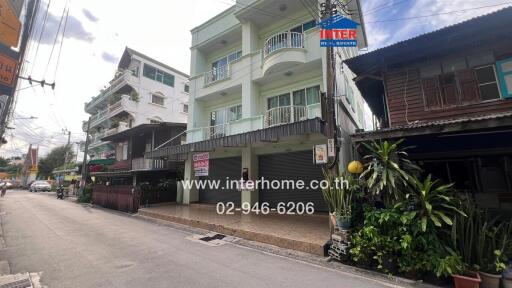 Exterior view of a three-story residential building with a sign from Inter Home Real Estate.