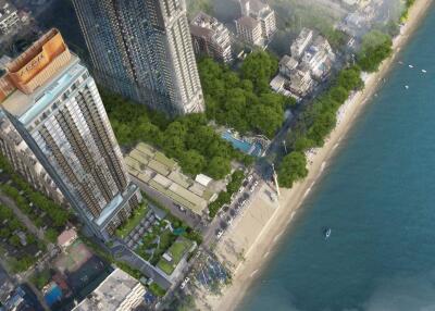 Aerial view of a beachfront high-rise building surrounded by other buildings and greenery.